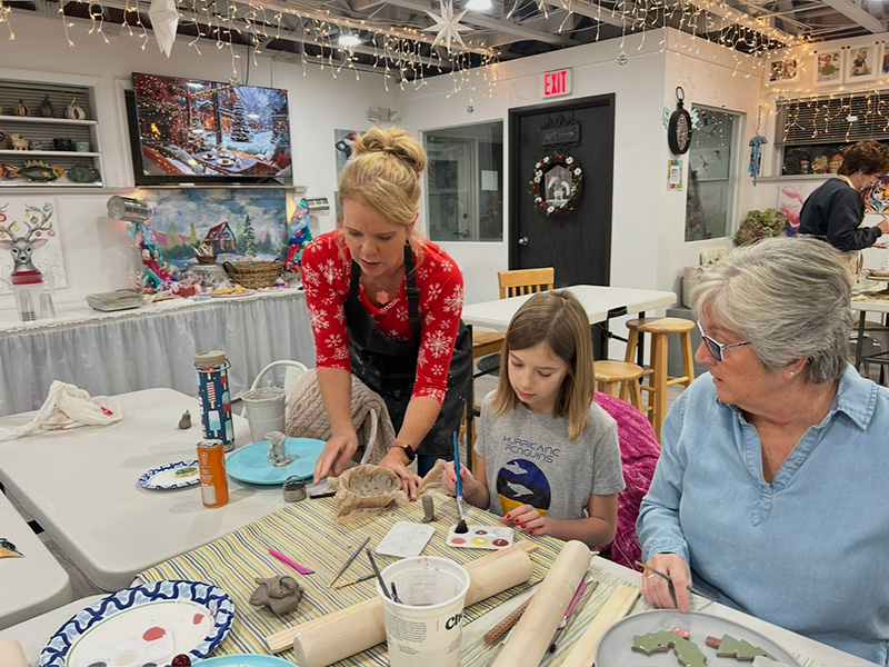 Betsy helping pottery student